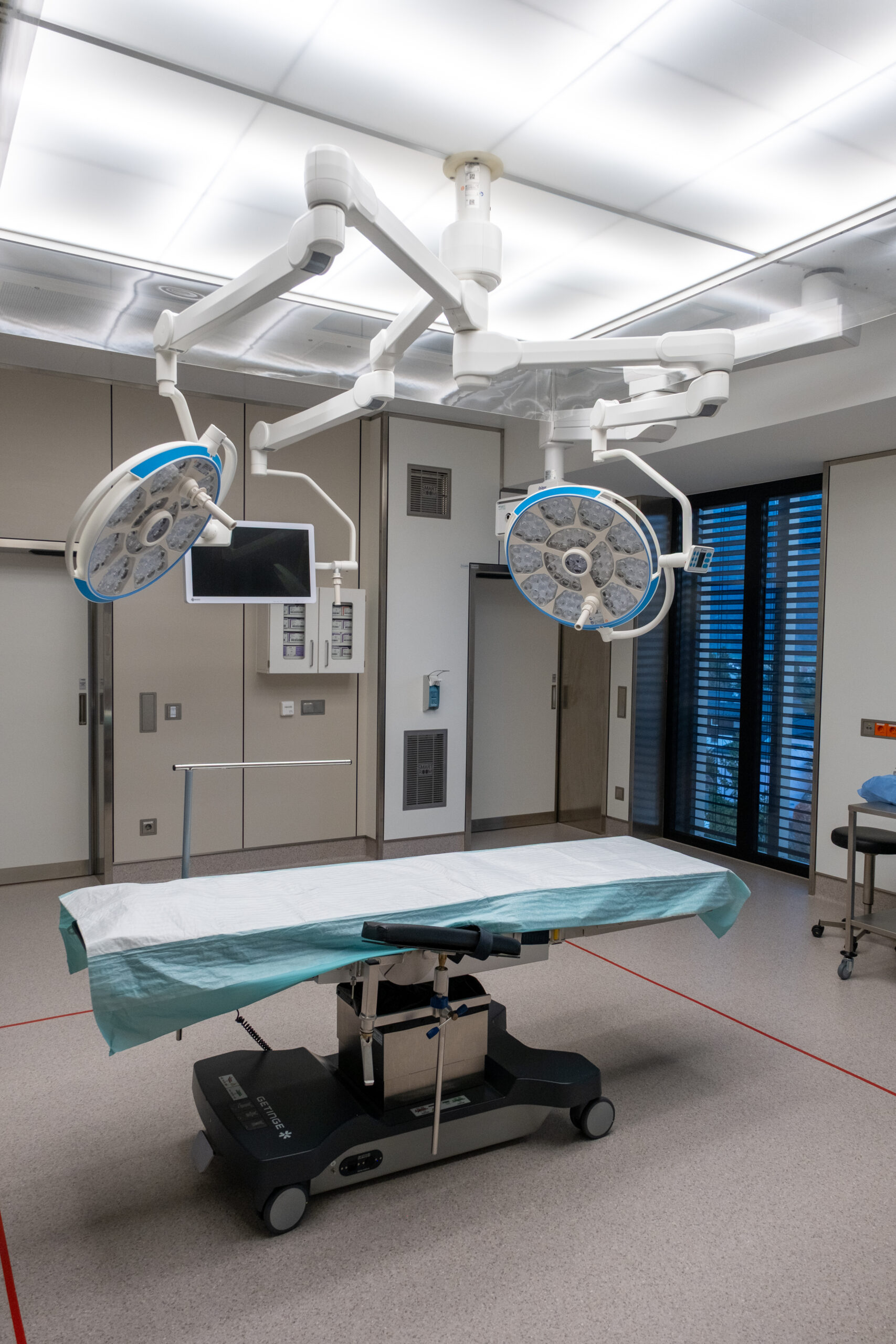 OP-Saal mit OP-Tisch und zwei Decken-OP-Leuchten.