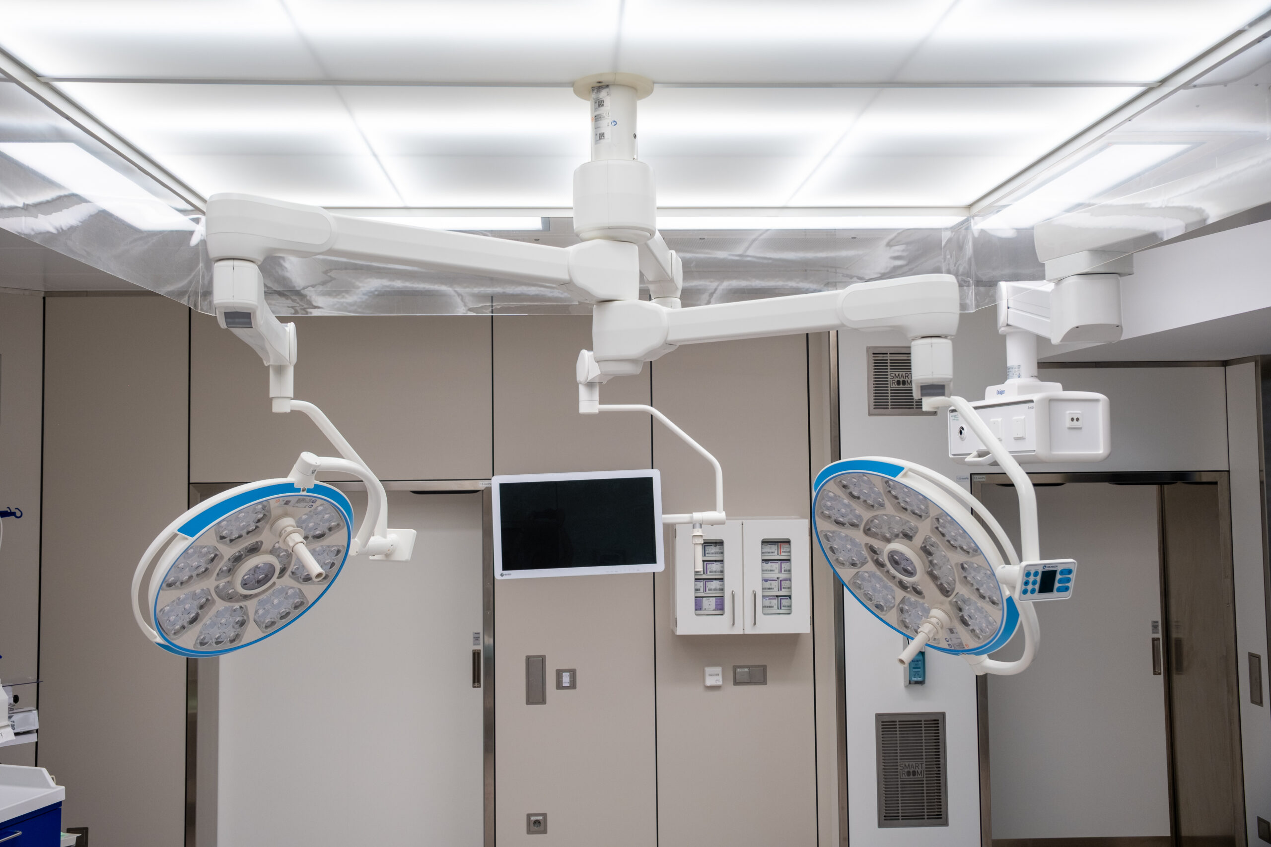 Zwei Decken-OP-Leuchten und ein Monitorarm über dem OP-Bereich.