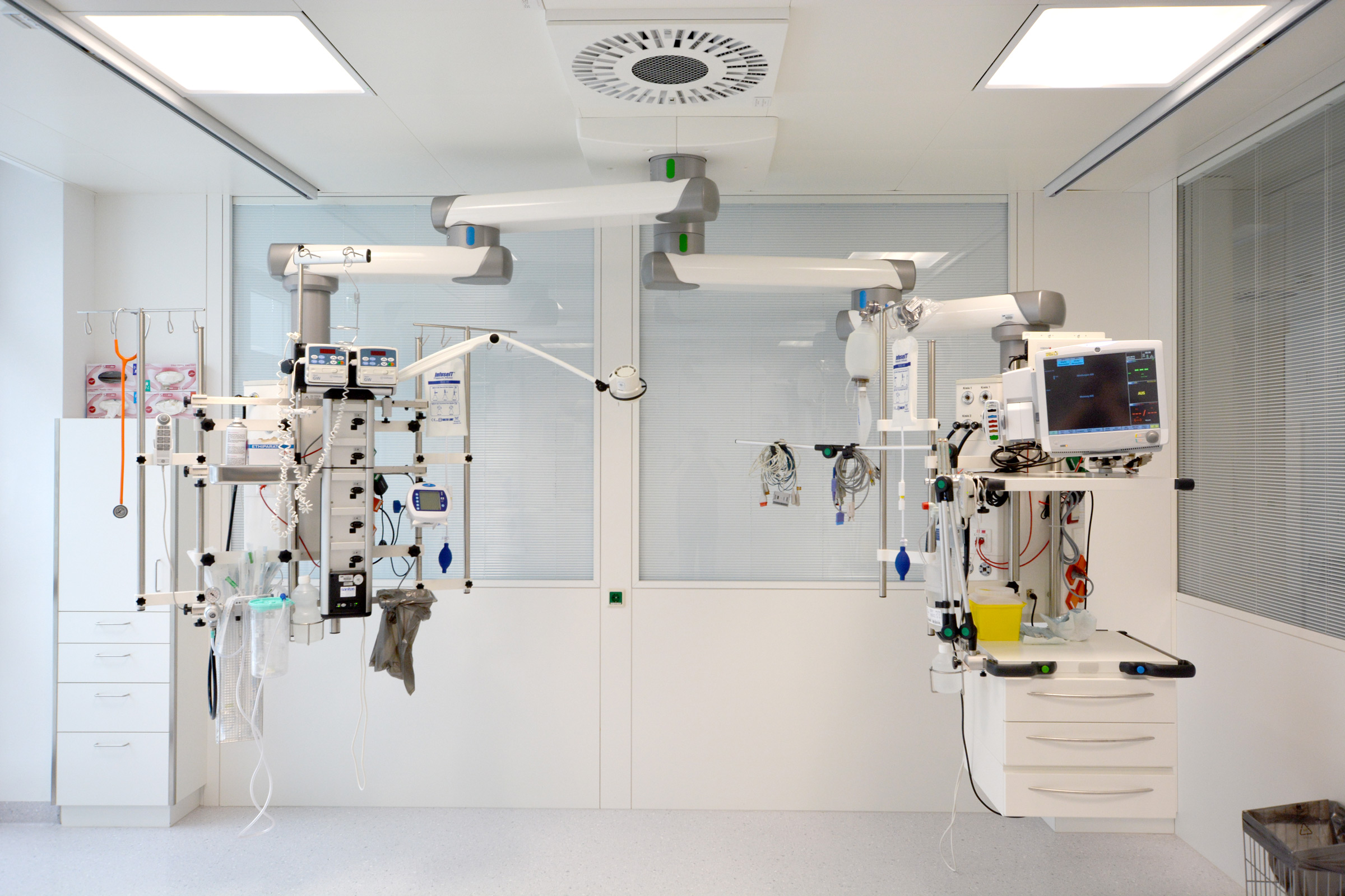 Intensiv-Deckenpendel mit Strom- und Gasanschlüssen, Infusionspumpen, Monitorhalterung und Schwenkarmen für die Patientenversorgung im Intensivbereich.